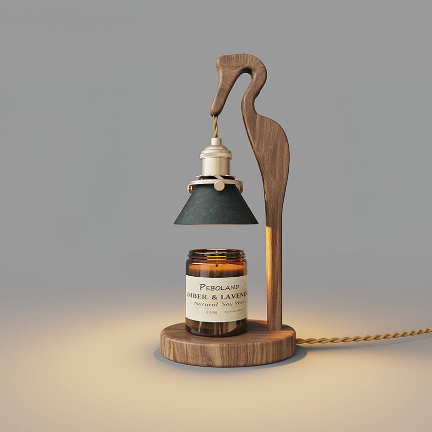 Heron lamp lit above a candle jar, the green shade glowing warm