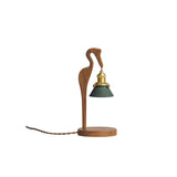 Walnut heron candle warmer lamp on a plain ground with its twisted cord