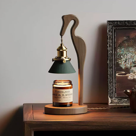 Heron lamp lit on a table beside a gilt framed picture and a mirror
