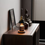 Heron lamp lit on a sideboard beside a small statue and a frame