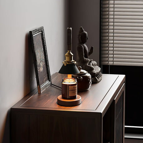 Heron lamp lit on a sideboard beside a small statue and a frame