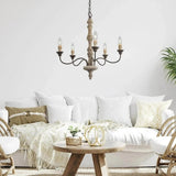 Lit above a white sofa and a small round wood coffee table with cushions and a throw