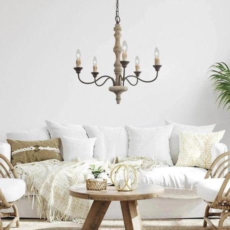 Lit above a white sofa and a small round wood coffee table with cushions and a throw