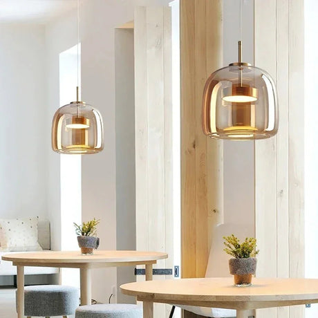Two glass shades above wooden tables in a cafe