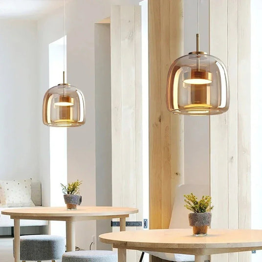 Two glass shades above wooden tables in a cafe