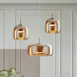 Three amber glass shades hung at staggered heights