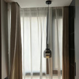 Single glass shade in a room with long curtains