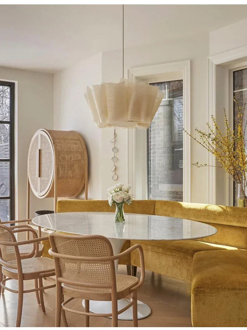 Pleated fabric shade above a dining table in a white room