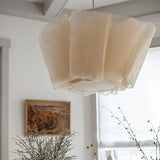 Ceiling light with a pleated fabric shade lit in a bright room