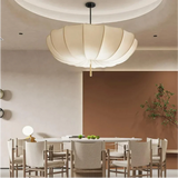 Scalloped cloth shade above a dining table with wooden chairs