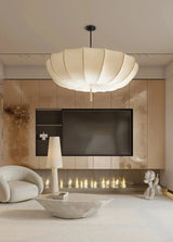 Scalloped cloth shade in a pale living room with a long fireplace