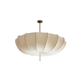 Scalloped cream cloth shade photographed against a plain gray ground