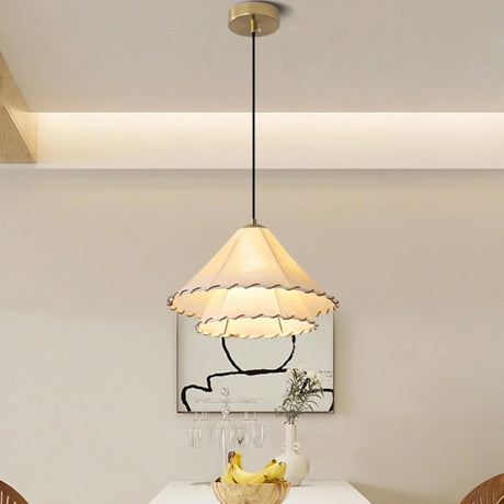 The two tier shade above a black round table with chairs and a dried plant vase