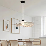 The flat shade over a kitchen counter with a vase of flowers and a hob behind