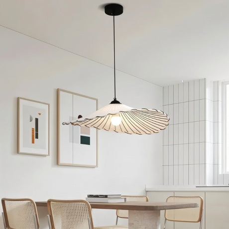 The flat shade over a kitchen counter with a vase of flowers and a hob behind