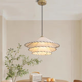 The two tier shade lit above a round table with a fruit bowl and cane chairs