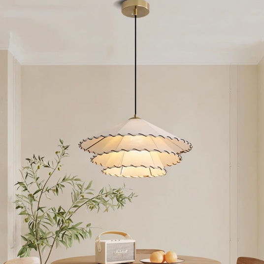 The two tier shade lit above a round table with a fruit bowl and cane chairs