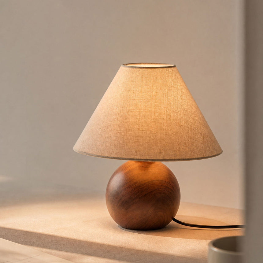 Close view of the lit linen shade above the wood grain ceramic orb