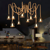 Lit above seating and tables in a room with a staircase and a mural behind
