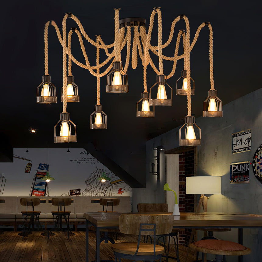 Lit above seating and tables in a room with a staircase and a mural behind
