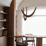 The dark arcs above a wood desk and chair beside built-in bookshelves