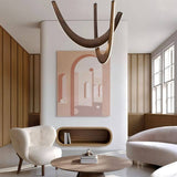 The dark arcs lit in a living room above a round coffee table, armchair and framed artwork
