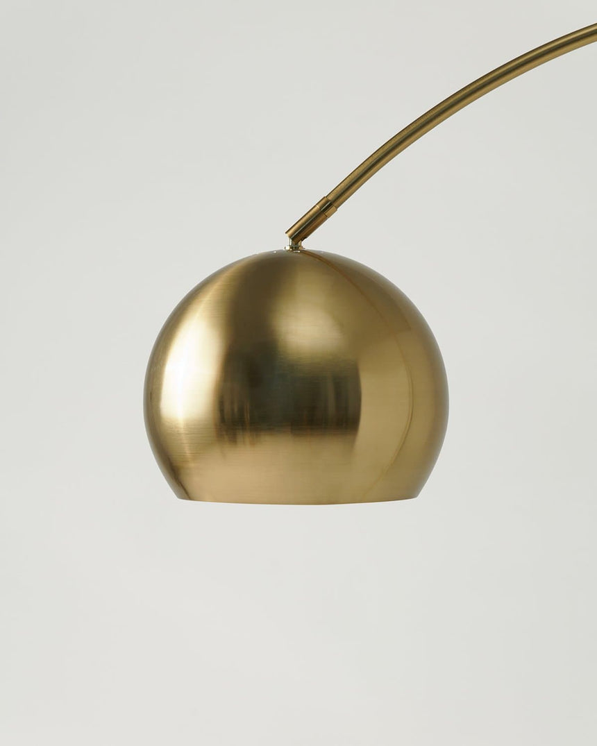 The brass dome shade seen close, the stem entering it at a single point