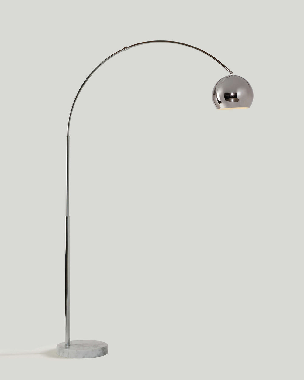 Chrome arc floor lamp with a metal dome shade on a round white marble base