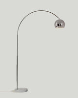 Chrome arc floor lamp with a metal dome shade on a round white marble base