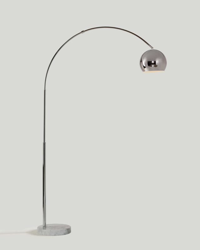 Chrome arc floor lamp with a metal dome shade on a round white marble base