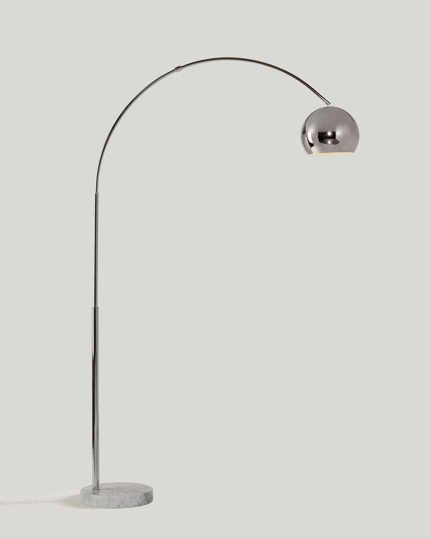 Chrome arc floor lamp with a metal dome shade on a round white marble base