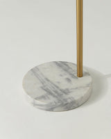 The round white marble base seen close with the brass pole rising from it