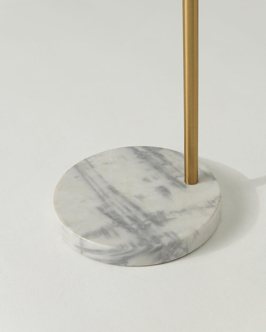 The round white marble base seen close with the brass pole rising from it