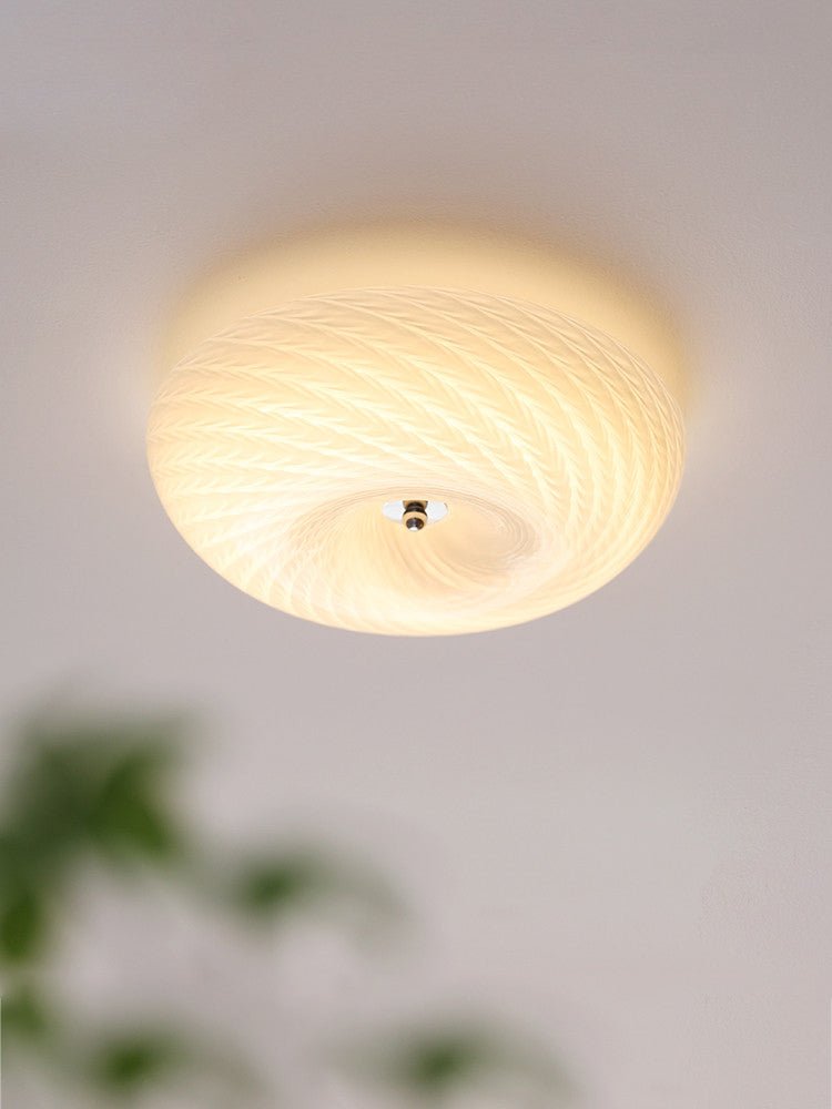 Swirled glass ceiling light seen close against a plain ceiling
