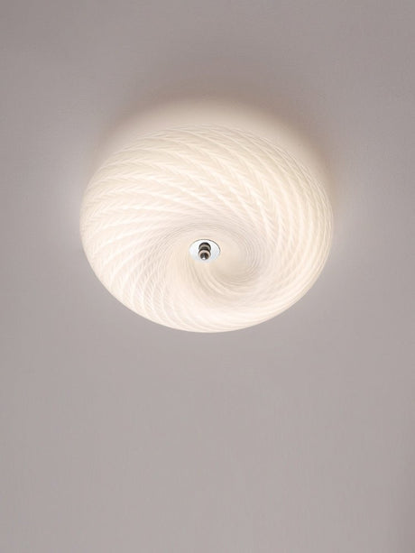 Swirled glass ceiling light lit and seen from below at an angle