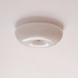 Swirled glass ceiling light unlit against a pale gray ceiling