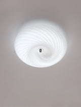 Lit swirled glass ceiling light seen from below with the spiral in full view