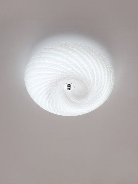Lit swirled glass ceiling light seen from below with the spiral in full view