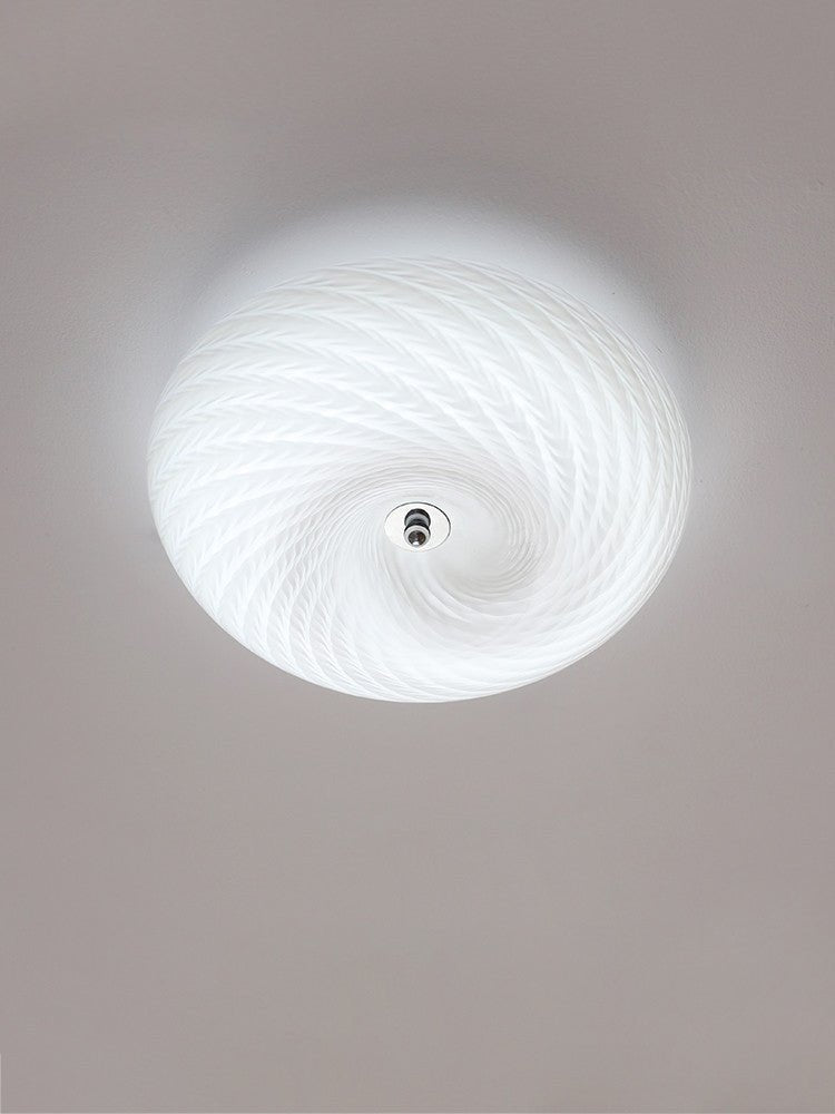 Lit swirled glass ceiling light seen from below with the spiral in full view