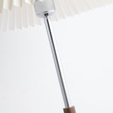 Close view of the polished chrome stem meeting the walnut collar