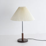 Chrome stem table lamp unlit seen from a slight angle with its cord