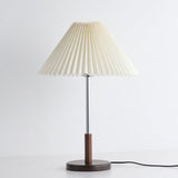 Chrome stem table lamp unlit against a pale ground, pleats clearly visible