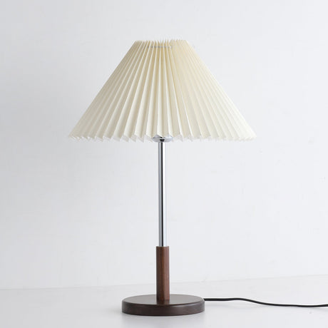 Chrome stem table lamp unlit against a pale ground, pleats clearly visible