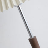 Close view of the chrome stem and the turned walnut section set into it