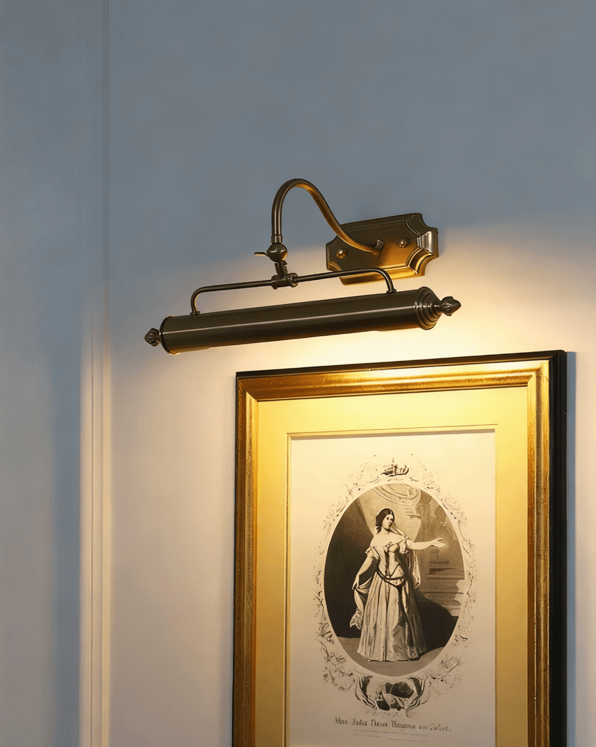 The gold version lit close above a gilt framed engraving, the arm curving forward