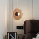 The glass disc hung upright beside an armchair and framed artwork