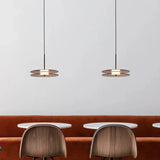 Two discs hung flat above a banquette with wooden chairs below