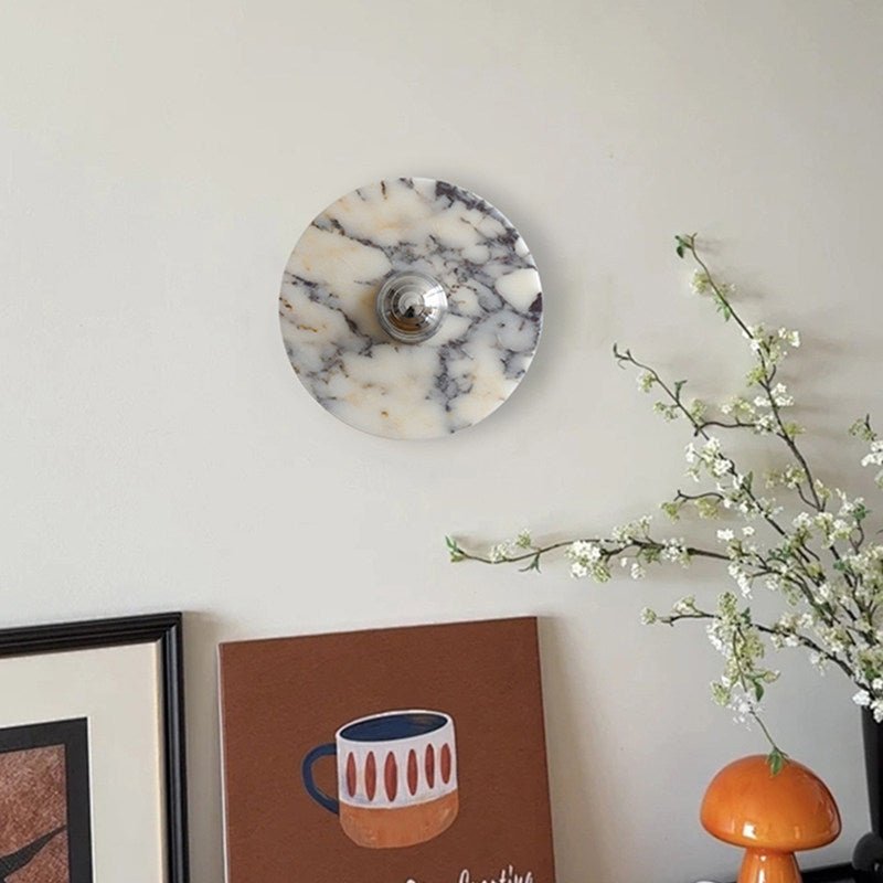 The marble disc above framed art and a flowering branch