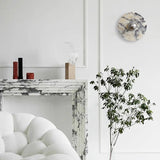 The marble disc above a marble fireplace and a white armchair