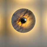 The marble disc lit, warm light glowing around its edge